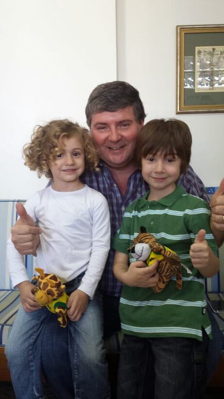 Dois pacientes do Dr. Ricardo fazendo joia e segurando bichinhos de pelúcia