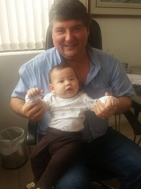 Dr. Ricardo com um bebê paciente no colo