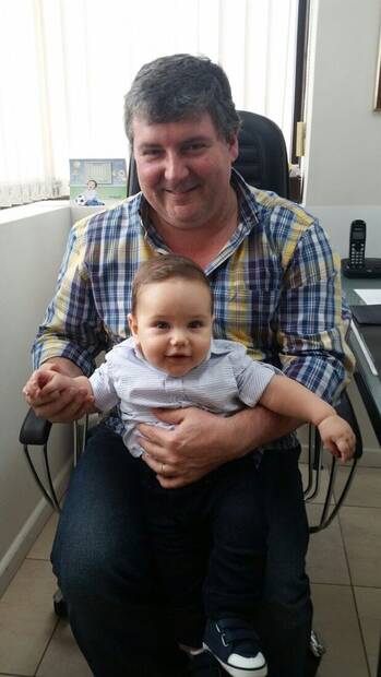 Dr. Ricardo com um bebê paciente no colo